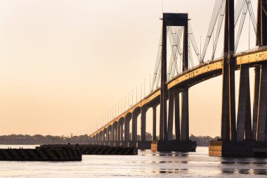 Corrientes Bridge seen from the coast during sunset on a sunny day - Corrientes, Argentina. clipart