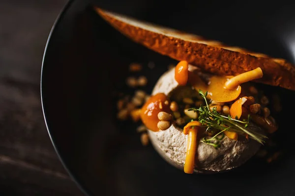 Mantarlı tavuk ciğeri ezmesi ve siyah tabakta fındık.