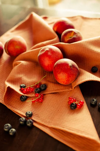 Durgun şeftali, yaban mersini, masa örtüsü üzerinde üzümlü üzümler.