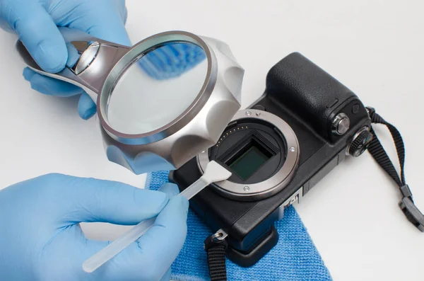 デジタルカメラマトリックスのクリーニング デジタルカメラサービス 虫眼鏡の下の手袋のマスターは 洗浄モップを使用して汚染からデジタルカメラのマトリックスをきれいにします — ストック写真