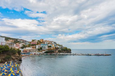 Bali, Girit, Yunanistan - 7 Ekim 2019: Popüler Girit tatil beldesinin muhteşem deniz, sahil, zarif dağ evleri, bir rıhtım ve tekneleri olan renkli körfezi