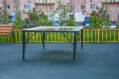 Bahçedeki oyun parkında tenis masası. Su birikintisindeki yansıma. Uzayı kopyala Krasnogorsk, Moskova bölgesi, Rusya - 17 Mayıs 2020