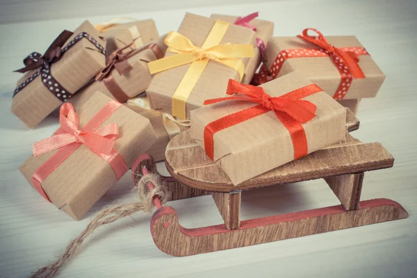 Vintage foto, trä släde och inslagna presenter till jul eller andra firande — Stockfoto