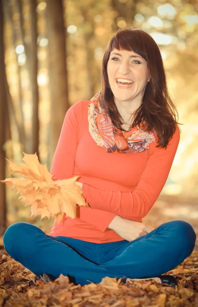 复古照片，微笑的女人在秋天公园与叶子在手中 — 图库照片