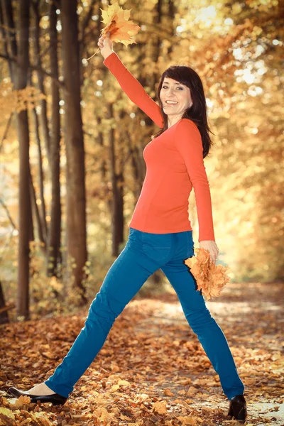 Vintage foto, Sorridente donna nel parco autunnale con le foglie in mano — Foto Stock