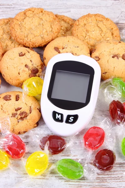 Glucometer and colorful candies with cookies, diabetes, reduction eating sweets — Stock Photo, Image