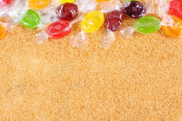Dulces coloridos y azúcar de caña morena granulada, concepto de diabetes — Foto de Stock
