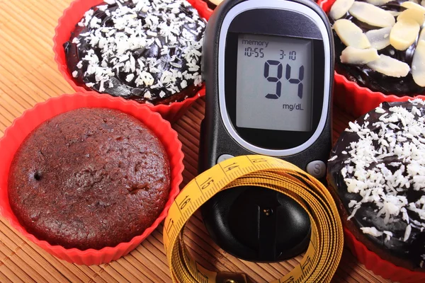 Glucometer, muffins em copos vermelhos e fita métrica — Fotografia de Stock