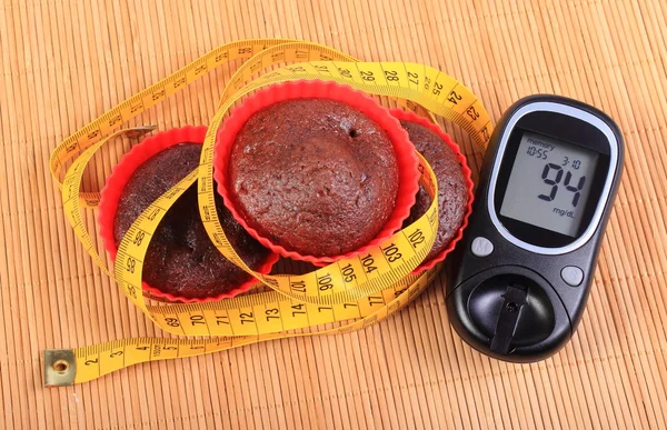 Glukometer, Muffins in roten Tassen und Maßband — Stockfoto