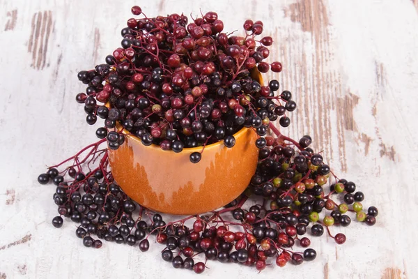 Bunch of fresh elderberry on old wooden background, healthy food — Stock Photo, Image