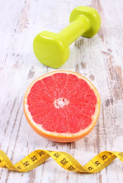 Fresh grapefruit, centimeter and dumbbells for fitness, healthy lifestyles — Stock Photo, Image