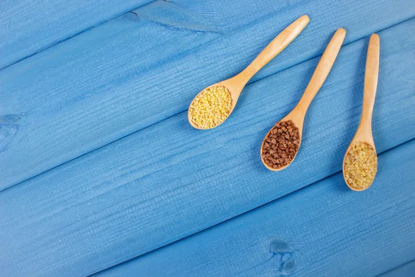 Varie semole su cucchiai di legno, cibo sano e nutrizione, spazio copia per il testo — Foto Stock