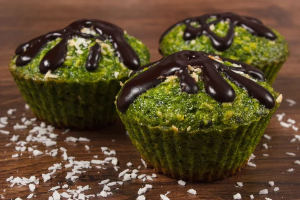 Fresh muffins with spinach, desiccated coconut and chocolate glaze, delicious healthy dessert — Stock Photo, Image