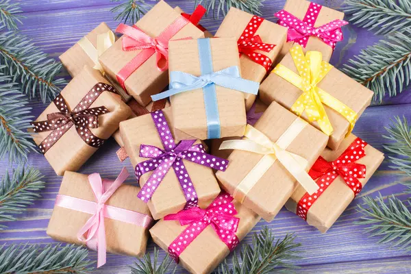 Τυλιγμένα δώρα με πολύχρωμες κορδέλες για τα Χριστούγεννα και ερυθρελάτης κλαδιά — Φωτογραφία Αρχείου