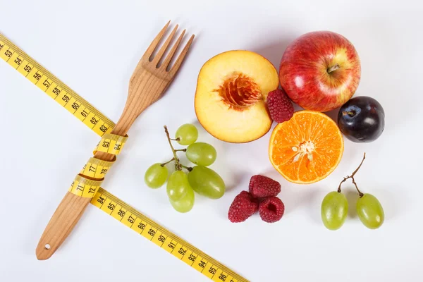 Свежие спелые фрукты и вилка с сантиметром на белом фоне — стоковое фото
