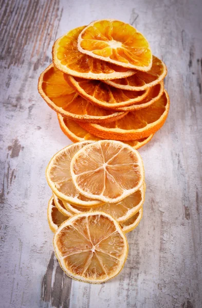 Slices of dried lemon and orange on old wooden background