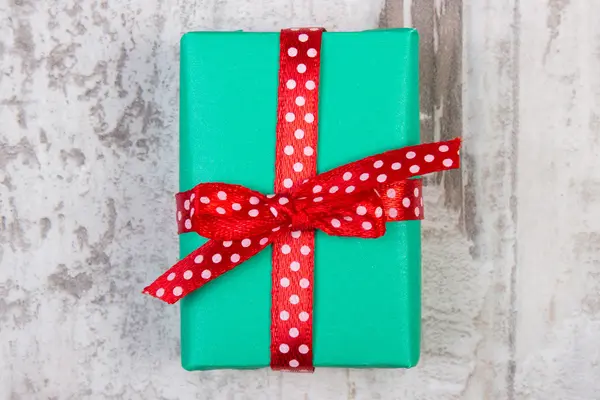 Grön gåva till jul eller andra firande på planka — Stockfoto