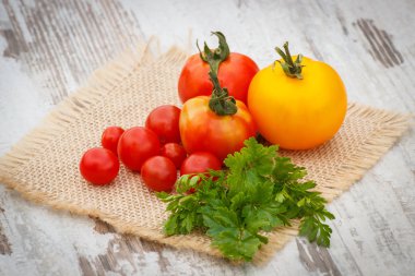 Bahçede güneşli jüt tuval üzerine yeşil yaprakları ile domates