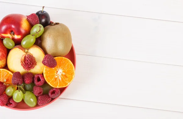 Frutas maduras frescas no prato deitado em placas brancas, espaço de cópia para texto — Fotografia de Stock