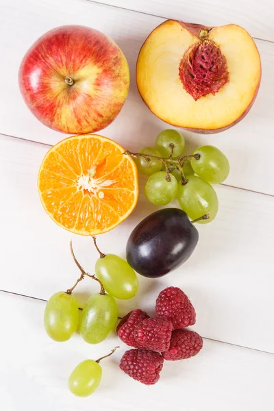 Свежие спелые фрукты на белых досках, здоровое питание — стоковое фото
