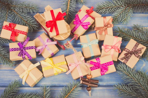 Ročník Foto, dřevěné sáňky a zabalené dárky s pásy pro Vánoce, smrkové větve — Stock fotografie