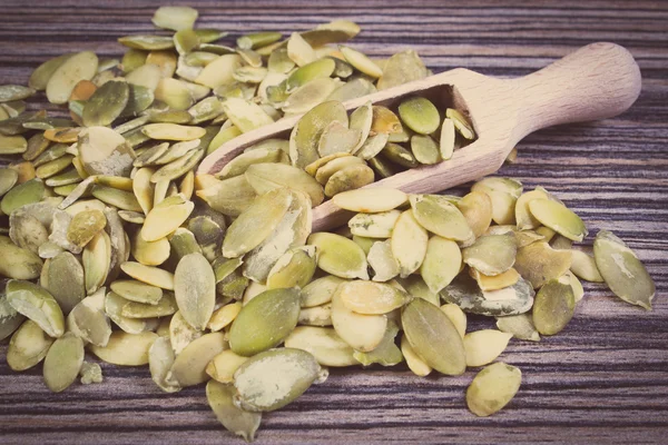 Винтажное фото, семена тыквы с ложкой на деревянном фоне — стоковое фото