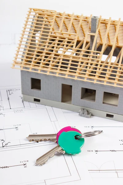 Llaves del hogar y pequeña casa en construcción en dibujos eléctricos, concepto de casa de construcción — Foto de Stock