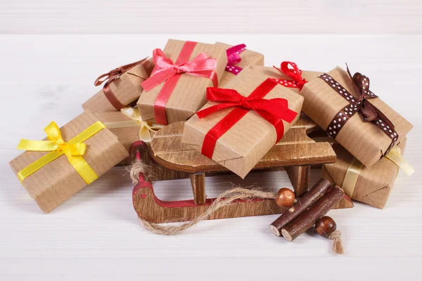 Sled de madeira e presentes embrulhados para o Natal ou outra celebração — Fotografia de Stock