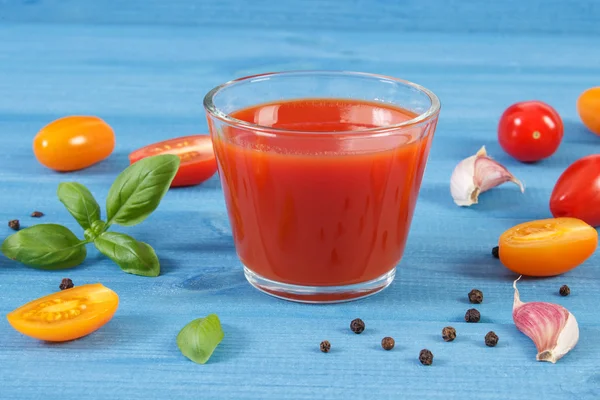 Tomatensap en fruit met specerijen op blauwe bord, gezonde voeding — Stockfoto