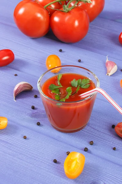 Tomato juice and vegetables with spices on blue board, healthy nutrition — Stock Photo, Image