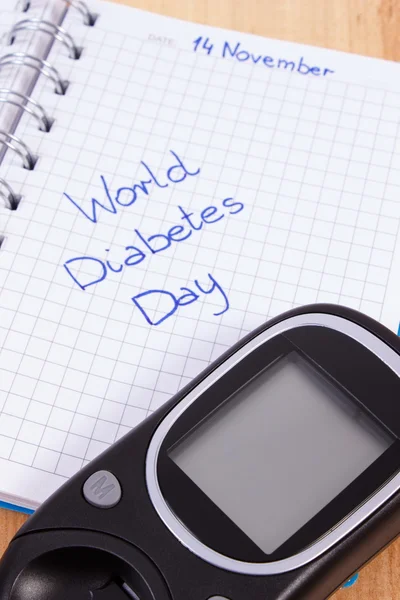 Glucometer e dia mundial da diabetes escrito em notebook — Fotografia de Stock