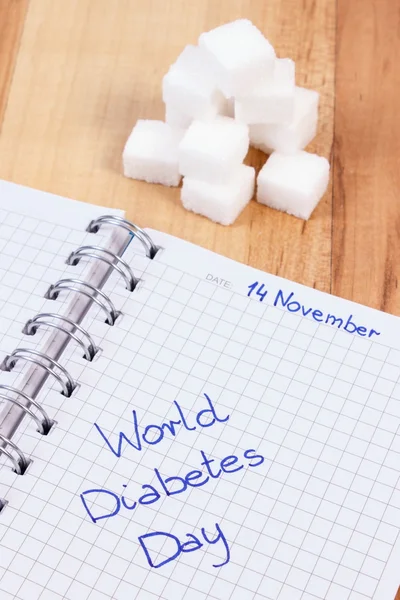 Felirat a cukorbetegek világnapja jegyzetfüzet és cukor kockákra, diabetikus jelképe — Stock Fotó