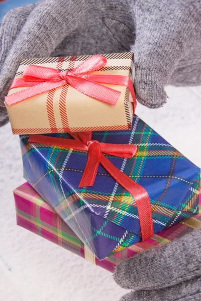 Manos de mujer en guantes con regalo para Navidad u otra celebración — Foto de Stock