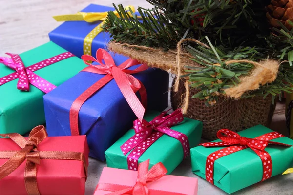 Innpakkede fargerike gaver til jul med juletre på gamle, hvite planker – stockfoto