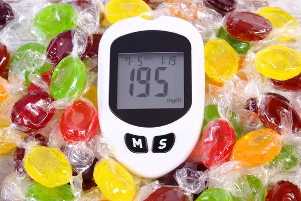 Glucometer e doces coloridos, diabetes, redução comer doces — Fotografia de Stock