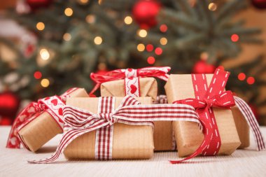 Sarılmış hediyeler ve arka planda ışıkları ile Noel ağacı