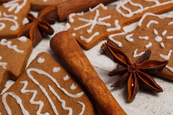 Frisch gebackene dekorierte Lebkuchen mit Gewürzen auf altem Holzgrund, Weihnachtszeit — Stockfoto