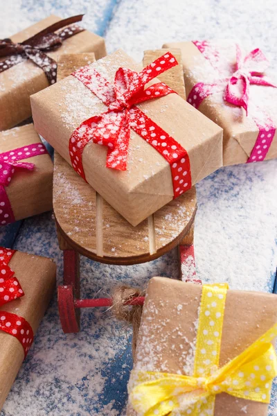 Ξύλινο έλκηθρο και τυλιγμένα δώρα για τα Χριστούγεννα ή άλλη γιορτή στο χιονισμένο σανίδες — Φωτογραφία Αρχείου