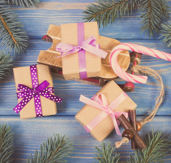 Vintage photo, Wooden sled and wrapped gifts with ribbons for Christmas, spruce branches — Stock Photo, Image