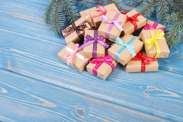Τυλιγμένα δώρα με πολύχρωμες κορδέλες για τα Χριστούγεννα και ερυθρελάτης κλαδιά, αντίγραφο χώρου για το κείμενο — Φωτογραφία Αρχείου