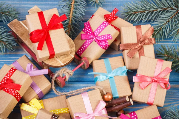 Trineo de madera y regalos envueltos con cintas para Navidad, ramas de abeto — Foto de Stock