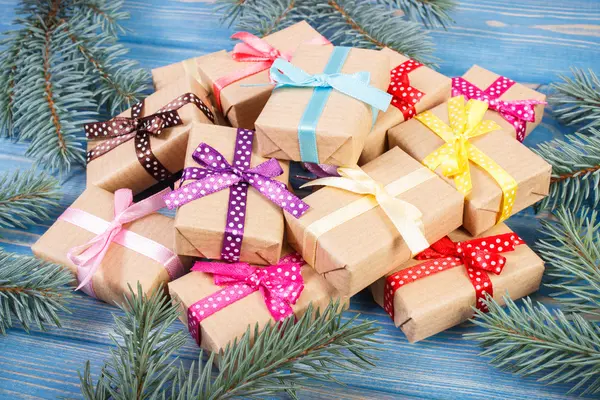 Regalos envueltos con cintas de colores para Navidad y ramas de abeto — Foto de Stock