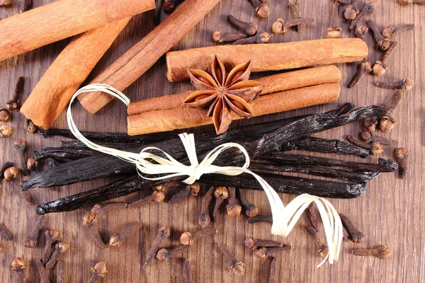 Vainilla, palitos de canela, anís estrellado y clavo de olor en la superficie de madera —  Fotos de Stock