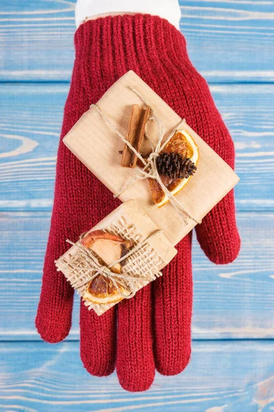 Το χέρι της γυναίκας στα γάντια με διακόσμηση δώρα για τα Χριστούγεννα ή άλλη γιορτή — Φωτογραφία Αρχείου