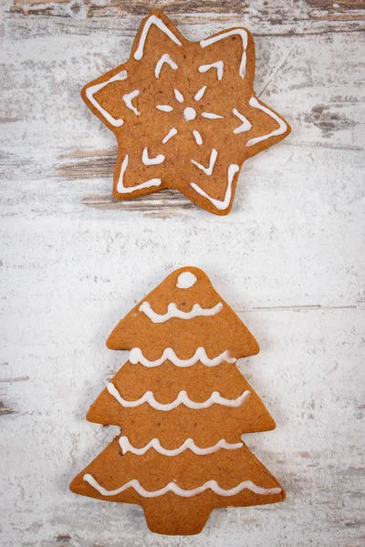 Fresh baked decorated gingerbread on old wooden background, christmas time — Stock Photo, Image