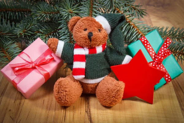 Osito de peluche con regalos para Navidad, ramas de abeto y estrella roja — Foto de Stock