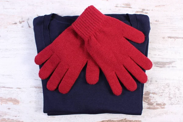 Ζευγάρι μάλλινα γάντια και πουλόβερ για γυναίκα στο παλιό ξύλινο υπόβαθρο — Φωτογραφία Αρχείου