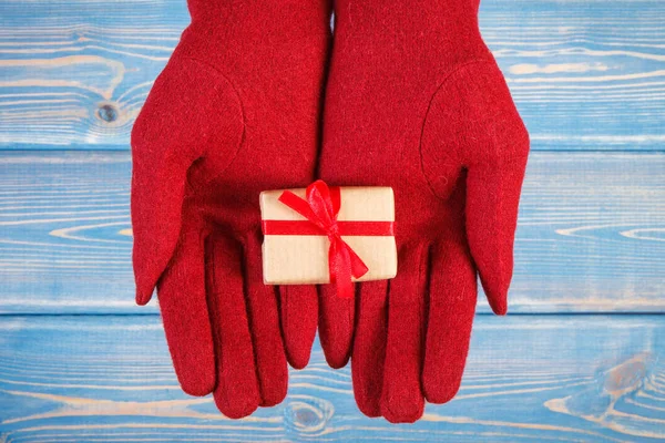 Τα χέρια της γυναίκας στα γάντια με δώρο για τα Χριστούγεννα ή άλλη γιορτή — Φωτογραφία Αρχείου