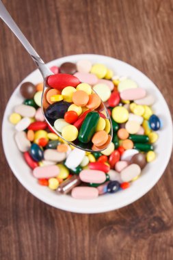 Çay kaşığı ve yığın renkli tıbbi kapsül içinde geçmiş, sağlık kavramı tıbbi ilaçlar