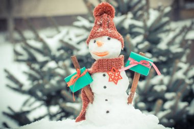 Vintage Fotoğraf, kardan adam ile iğne yapraklı ağaç arka plan üzerinde Noel ya da Sevgililer günü için hediye kar kaplı.